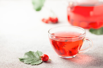 Hawthorn tea in a glass teapot and a cup on the table. Vitamin health drink.