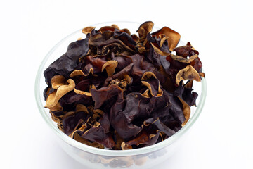 Dried black fungus in glass bowl on white background.