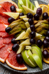 A stone dish filled with ripe tropical fruits as a wine snack in a winery