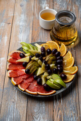 A huge fruit platter with watermelon, oranges, kiwi, apples, pear and grapes, top view