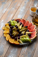 A huge fruit platter with watermelon, oranges, kiwi, apples, pear and grapes, top view