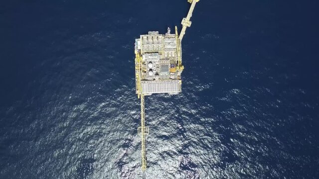 Drone shot of central processing platform (cpp) in the middle of the ocean on sunny day - upstream industry
