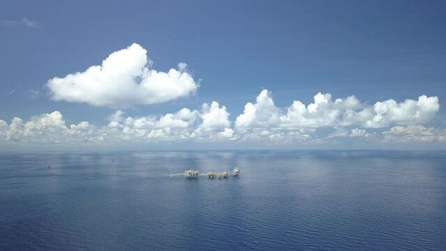 Drone shot of central processing platform (cpp) in the middle of the ocean on sunny day - upstream industry
