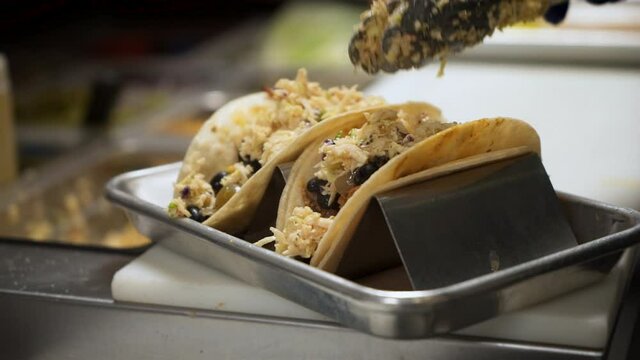 Chef Tops Fish Black Bean Tacos With Slaw, Cook Plates Tacos In Taco Stand Rack With Coleslaw, Slow Motion Close Up 4K