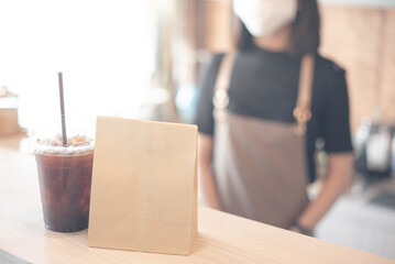 friendly woman barista or waitress wearing protection face mask waiting for serving hot coffee cup to customer in cafe coffee shop, cafe restaurant, service mind, new normal, food and drink concept