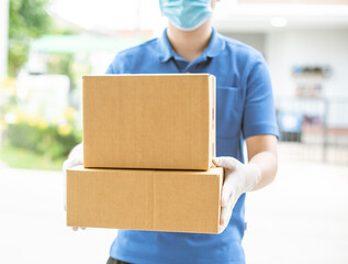 Deliver man wearing medical gloves and face mask in blue uniform handling parcel box give to female costumer Postman and express grocery delivery service during covid19., newnormal, online, order