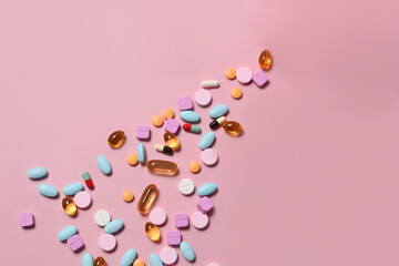 Pharmaceutical tablets and capsules on pink background. Medical health care concept.