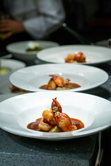 Chefs standing at table in kitchen and decorating beautiful dishes high cuisine restaurant