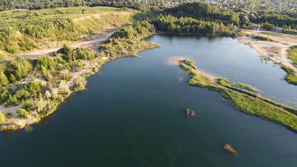 Flooded and overgrown sand quarry. Lush green summer landscape for outdoors vacation, hiking, camping or tourism. Volokolamsk district of Moscow region. Sychevo beach, Russia