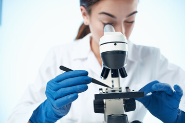 female laboratory assistant looking through a microscope research science technology