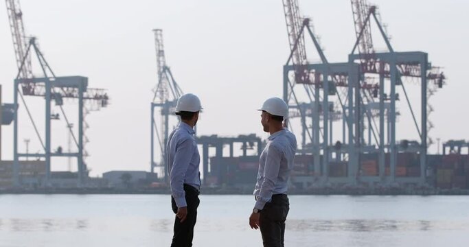 The investor shows the businessman the possibilities of marine logistics for trade, points his hand towards the seaport with cargo containers.