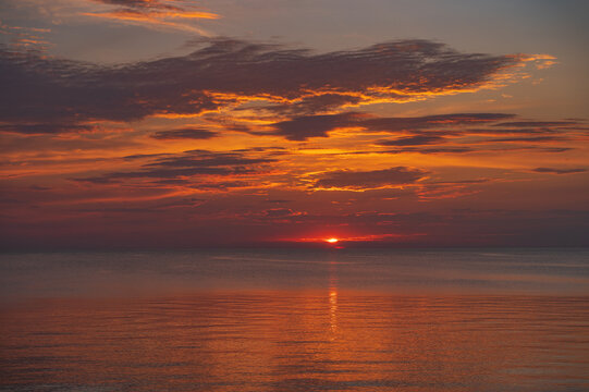 sunset in the sea with clouds and calm water © gatis_photo