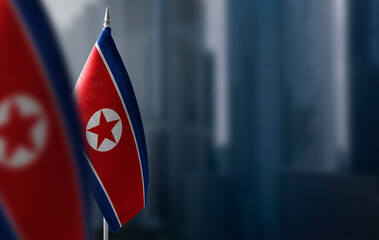 Small flags of North Korea on a blurry background of the city - 459050824
