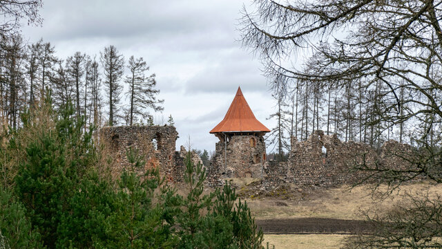 spring landscape with a view of the castle ruins, the new bright orange roof of the castle tower stands out, Ergeme castle ruins, Valka district, Latvia