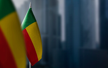 Small flags of Benin on a blurry background of the city