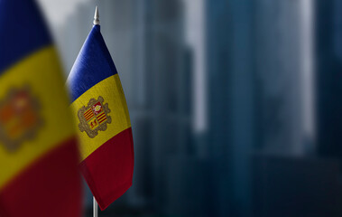 Small flags of Andorra on a blurry background of the city - obrazy, fototapety, plakaty