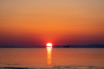 Fototapeta na wymiar Beautiful sunset over the sea and the silhouette of the ship