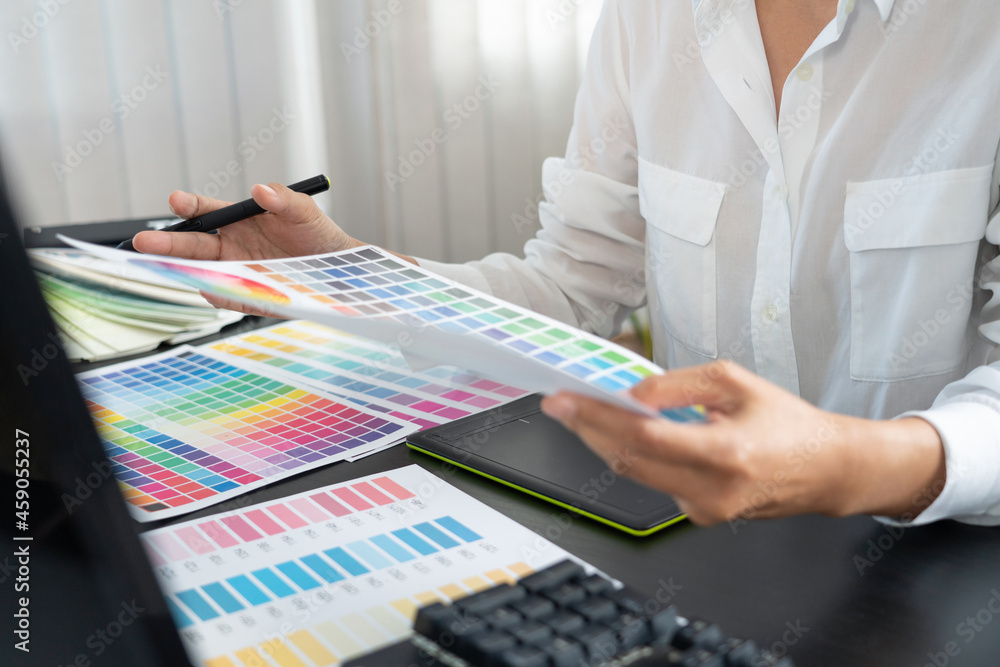 Poster creative graphic designer choosing color scale for editing artwork while working in office.