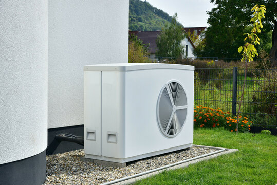 Wärmepumpe, Klimaanlage, Luftwärmepumpe für Heizung und Warmwasser vor einem neu gebauten Wohnhaus