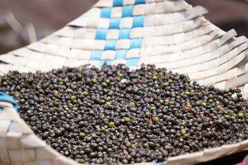 Sun dried black pepper on white surface