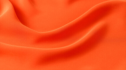 Abstract orange background. Silk fabric draped texture