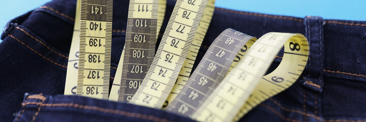 Yellow measuring tape is in jeans pocket closeup