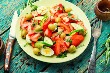 Salad with vegetables, olives, eggs and rosemary