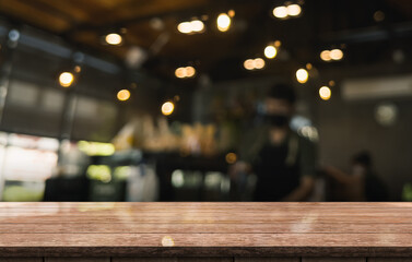 Empty wooden table top with lights bokeh on blur restaurant background.