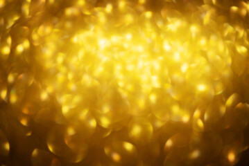 Defocus light sparkles of gold color as a background for designers. Luxury and gold.