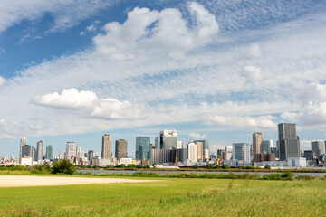 Obraz premium View of office buildings of central Osaka city from Yodogawa river bank