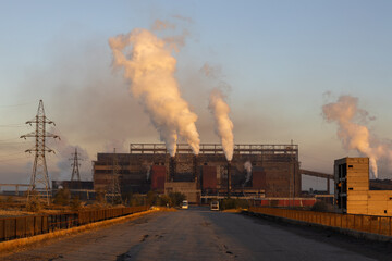 Fototapeta na wymiar Clouds of smoke and vapor rise out of Steel plant Temirtau at sunrise time in Temirtau, Kazakhstan.