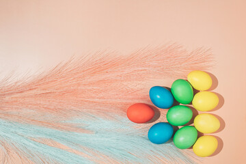 Spring Easter layout made of multicolored eggs with the addition of pink and blue decorations on a...