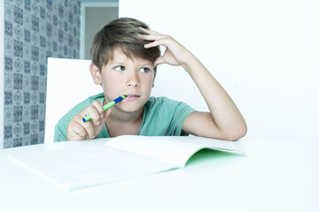 boy with book does school homework. Back to school. Unhappy schoolboy with textbooks. Distance learning