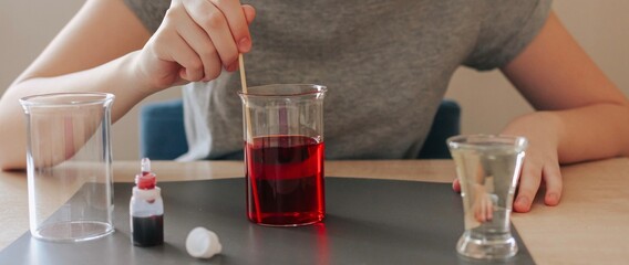 Lava lamp, science experiment with water, food coloring, oil and aspirin doing by school girl. Step by step process of doing homework. Education, back to school, distant banner.