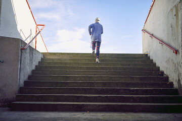 female image from the back running up the stairs. conceptual photo of success