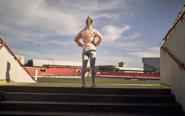 Fototapeta na wymiar A young girl is warming-up for a training at the stadium. Sport, athletics, athletes