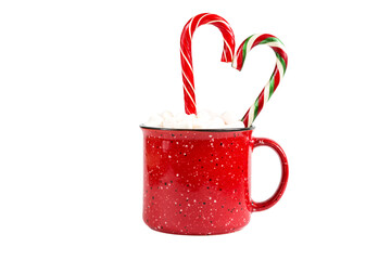 Red mug with marshmallows and caramel candy cane in the shape of a heart on a white background...