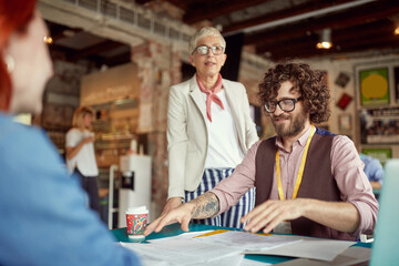 Young coworkers consulting with senior colleague