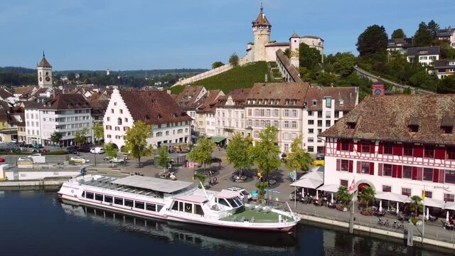 Aerial drone footage of the Schaffhausen old town by the Rhine river in Switzerland with the Munot medieval fortress. Shot with a tilt down motion. 