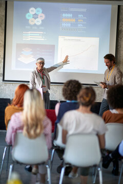 An elderly woman holding a presentation in the conference room. Employees, office, work