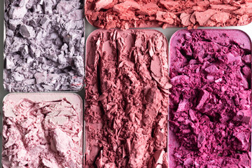 Cosmetic texture background. Broken eye shadows. Pink magenta decorative cosmetics 