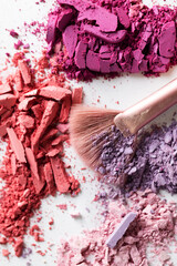 Cosmetic texture background. Broken eye shadows. Pink magenta decorative cosmetics 