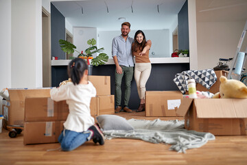 family- mother father and girl move to new apartment and unpack boxes