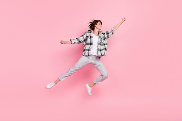 Full size photo of funky young brunette lady jump wear shirt trousers shoes isolated on pink background