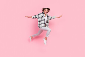 Full body photo of funny millennial brunette lady jump wear shirt trousers shoes isolated on pink background