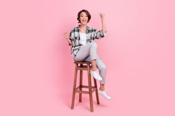 Full body photo of cool millennial brunette lady sit wear shirt trousers isolated on pink background