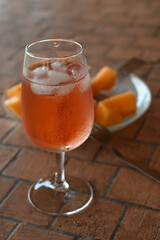 Verre de rosé avec une assiette de morceaux de melon