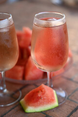 Verres de rosé avec des glaçons à côté d'un morceau de pastèque