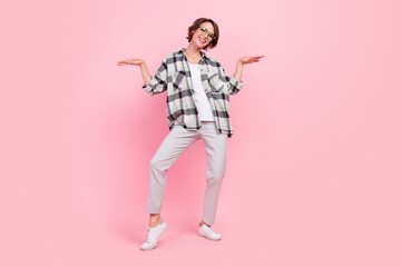 Full body photo of funky young brunette lady dance wear eyewear shirt trousers sneakers isolated on pink background