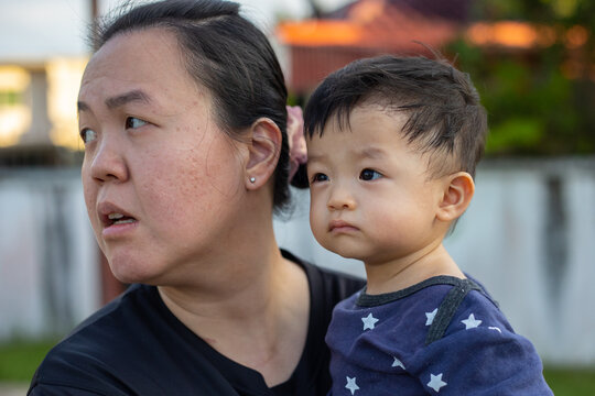 portrait image of A Chinese mother carry her Happy and cute Asian Chinese baby boy at park during evening